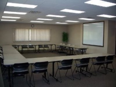 Picture of conference room with table, chairs and whiteboard.